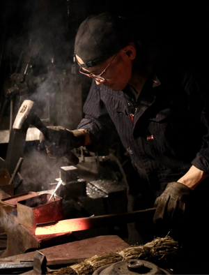 Jiro smeder japansk køkkenkniv i sit værksted – traditionelt håndværk fra Japan